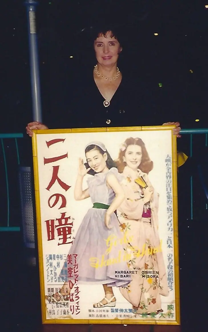 Margaret O'Brien holding a framed Japanese poster for the 1952 film Futari no Hitomi co-starring Hibari Misora
