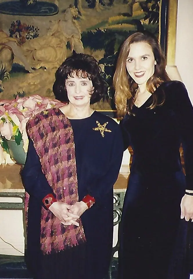Margaret O'Brien in a dark velvet dress with a gold Swoboda sea-star brooch, standing beside a friend